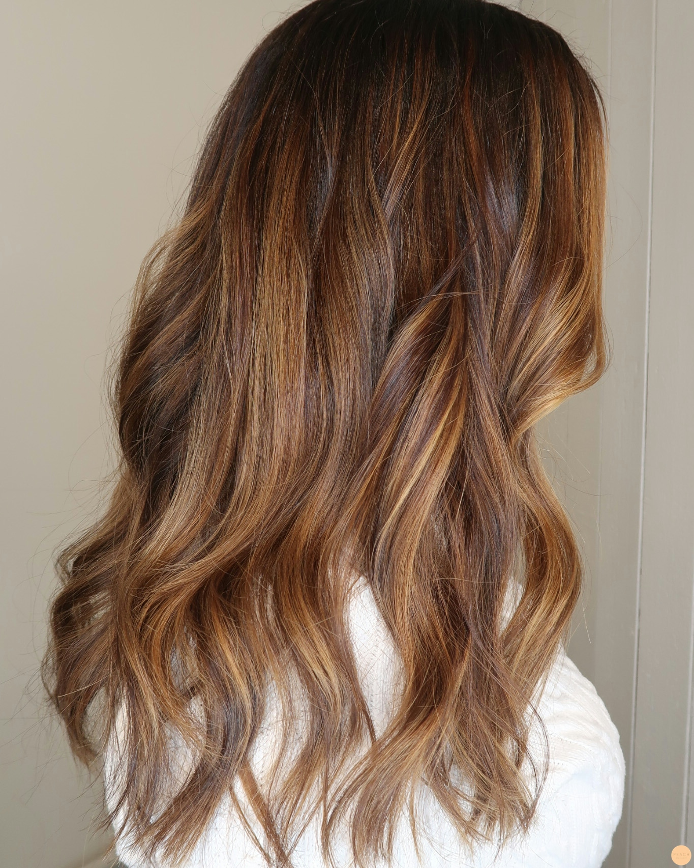 Brun hårfärg med slingor i ton av karamell och honung